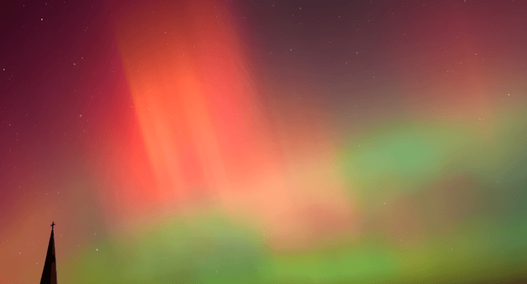 Редкое красно-зеленое северное сияние на фоне ночного неба